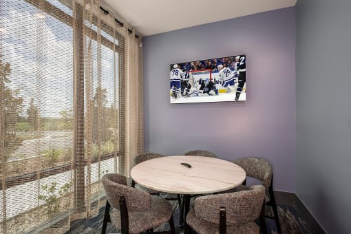 a dining room with a table and chairs and a tv on the wall
