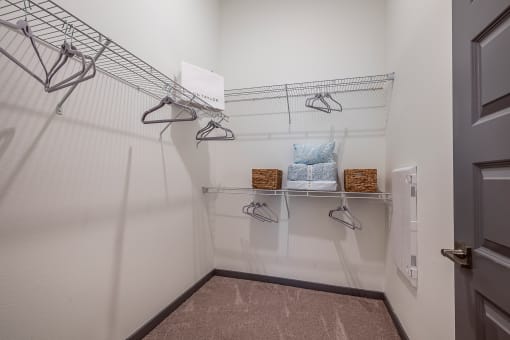 a walk in closet with shelves and hooks and a door