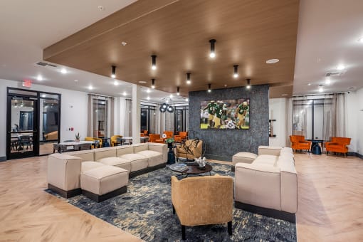 a lobby with couches and chairs and a large painting on the wall