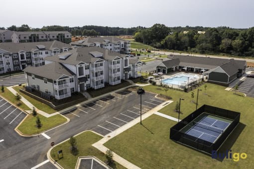 an aerial view of an apartment complex with a pool and tennis court