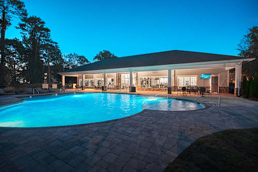 A pool in a backyard with a house in the background.