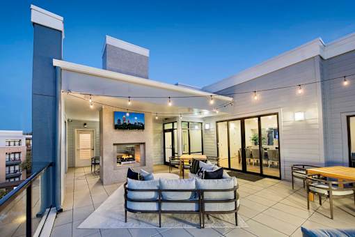 Luxury Apartments in Downtown Decatur, GA, With In-Unit Washer and Dryer - Reserve Decatur - Rooftop Lounge With Covered Seating, String Lights, Fireplace, and Outdoor Dining.