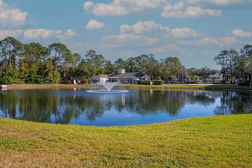 A fountain in the middle of a lake surrounded by trees.