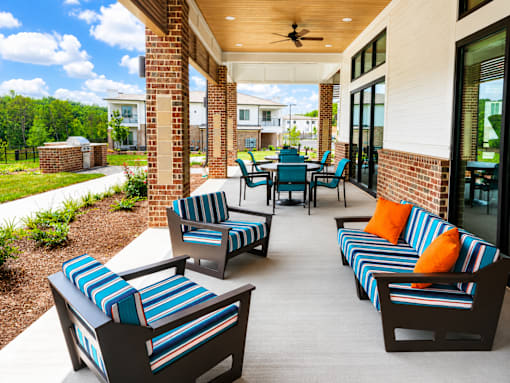 A patio with striped cushions and chairs.
