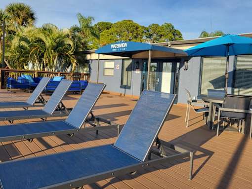 A water slide area with a blue umbrella and chairs.
