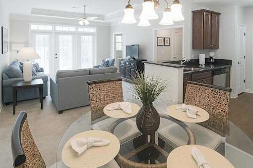 A modern dining room with a glass table and chairs.