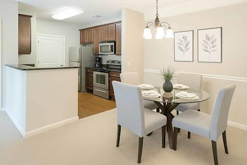 A kitchen with a dining table and chairs.