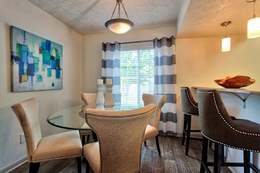 A dining room with a glass table and chairs.