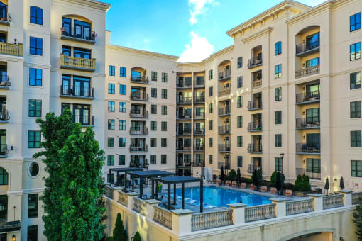 an exterior view of an apartment building with a large swimming pool