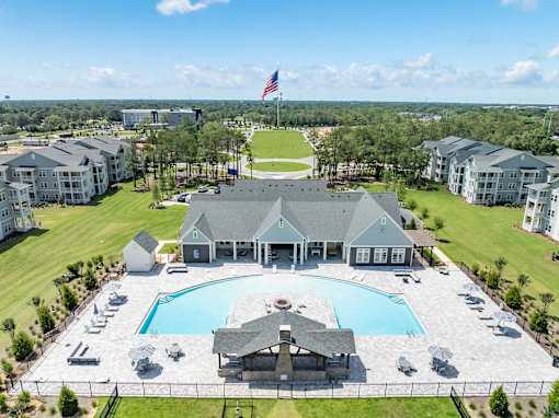 A large building with a pool in front of it.