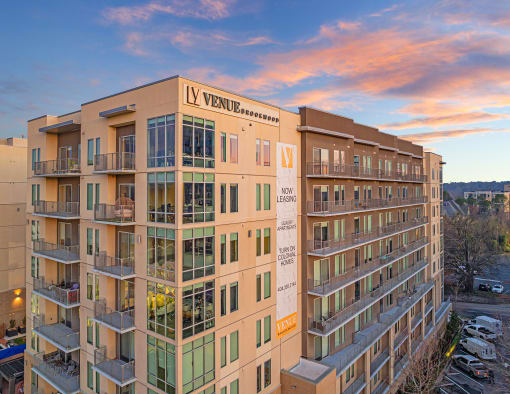 an apartment building with a sunset in the background