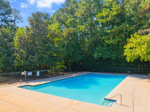 a swimming pool with trees in the background