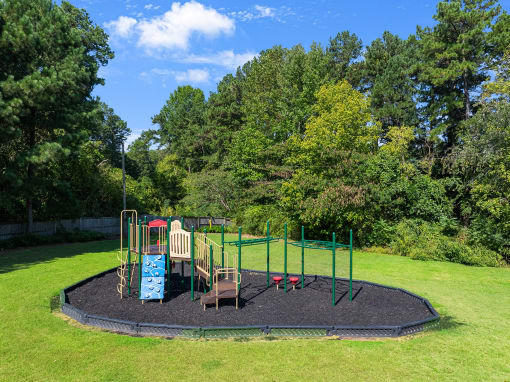 a playground in the middle of a park with trees