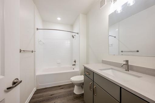 A white bathroom with a toilet, sink, and bathtub.