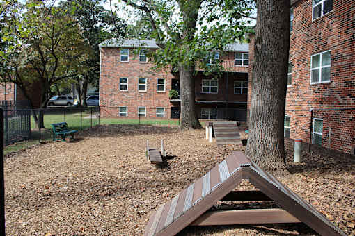 A playground with a slide in front of a brick building.