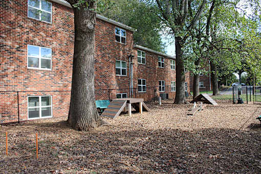 A playground area in front of a brick building.