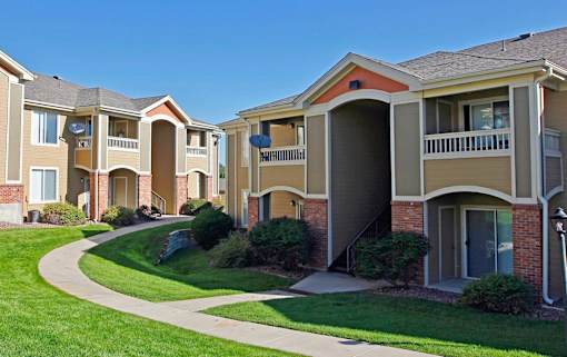 Apartment buildings with a green lawn in front.