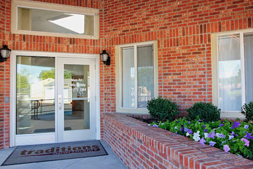 A red brick building with a glass door and window.