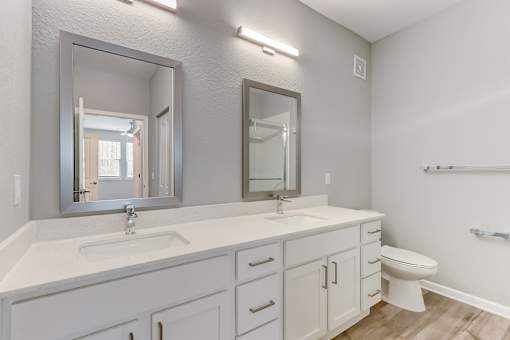 A bathroom with a white countertop and a large mirror above it.