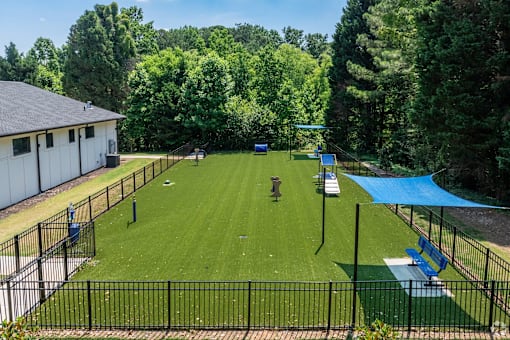 A park with a blue tarp and a black fence.