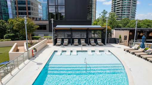 A large outdoor swimming pool with a diving board and lounge chairs.