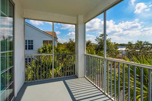 the view from the balcony of a home with large windows