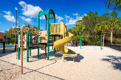 a playground with a large yellow slide in a park