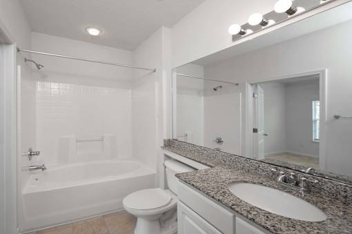 A white bathroom with a toilet, sink, and bathtub.