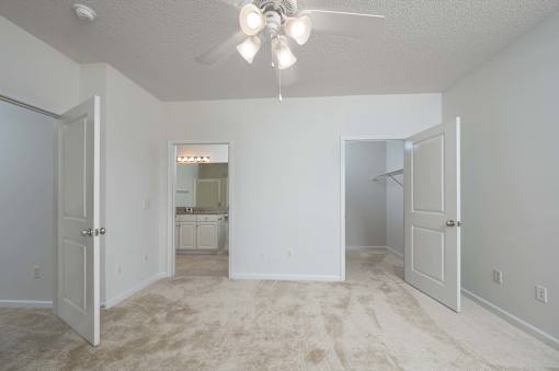 A room with a ceiling fan and carpeted floor.