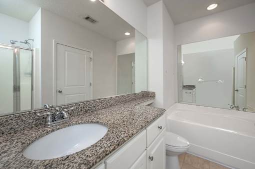 A bathroom with a sink, toilet, and bathtub.