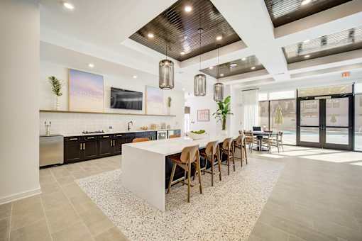 A modern kitchen with a long island and chairs.