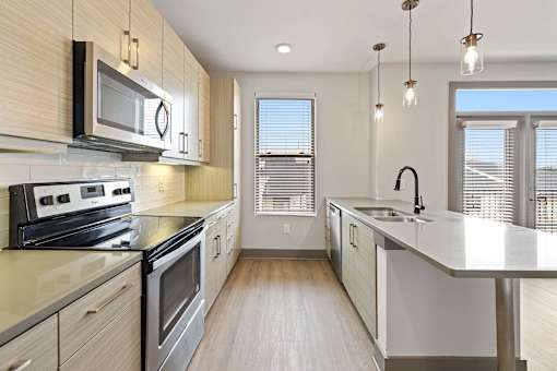 A modern kitchen with stainless steel appliances and wooden cabinets.