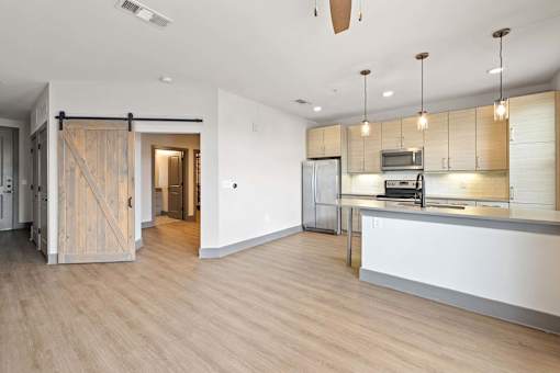 A kitchen area with a white counter and wooden floors.