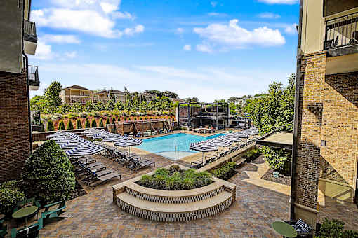 A pool surrounded by lounge chairs and umbrellas.
