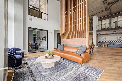 A modern living room with a brown leather couch and a white coffee table.