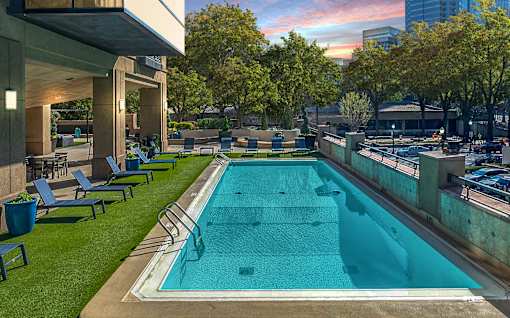 A rectangular pool with a metal railing and a concrete floor.
