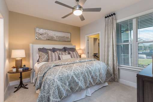 A bedroom with a large bed and a ceiling fan.
