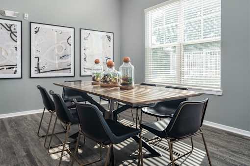 A dining table with chairs and a bottle of water on it.
