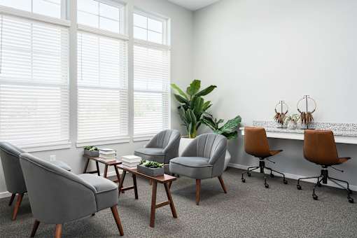 A room with a grey chair and a brown chair.
