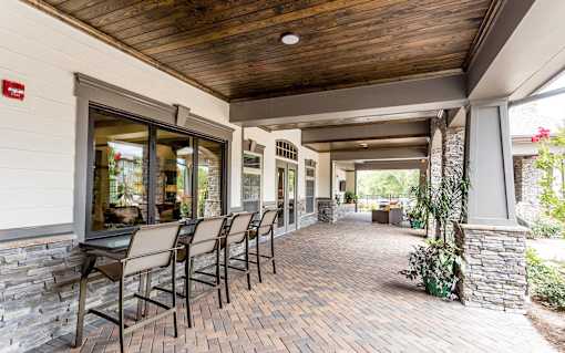a covered patio with a table and chairs