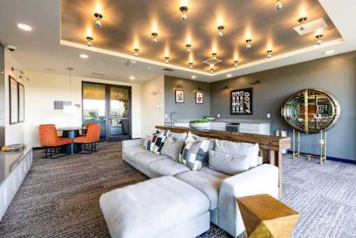 A modern living room with a grey carpet and a white sofa.
