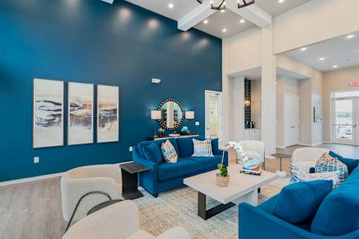 A living room with blue couches and a white coffee table.