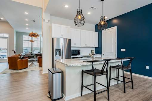 A kitchen with a bar stool and a bar counter.