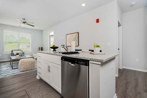 A modern kitchen with a stainless steel dishwasher and white cabinets.