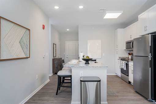 A kitchen with a white island and stainless steel appliances.