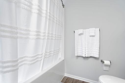 A white shower curtain in a bathroom.