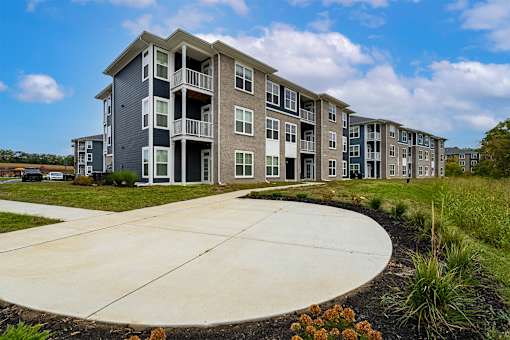 A large apartment complex with a circular driveway in front.