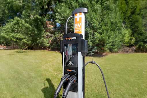 A ChargePoint electric vehicle charging station is located in a grassy area.