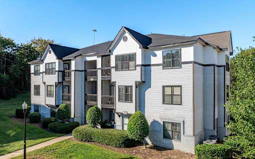 A large two-story apartment building with a balcony on the second floor.
