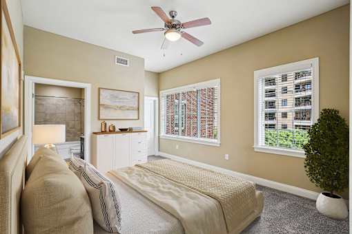 A bedroom with a bed, nightstand, and a ceiling fan.